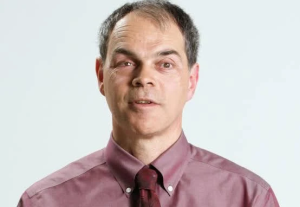 Headshot of Tony Labillois. Tony is wearing a red shirt with a red tie.